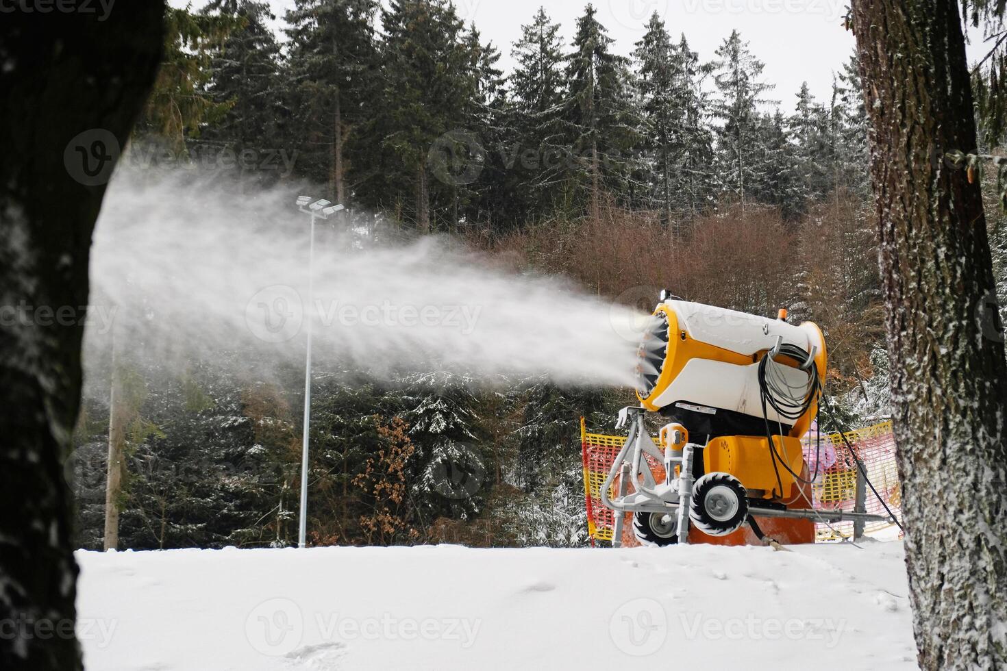 Snow cannon makes artificial snow. Snowmaking systems sprays water to produce snow. photo