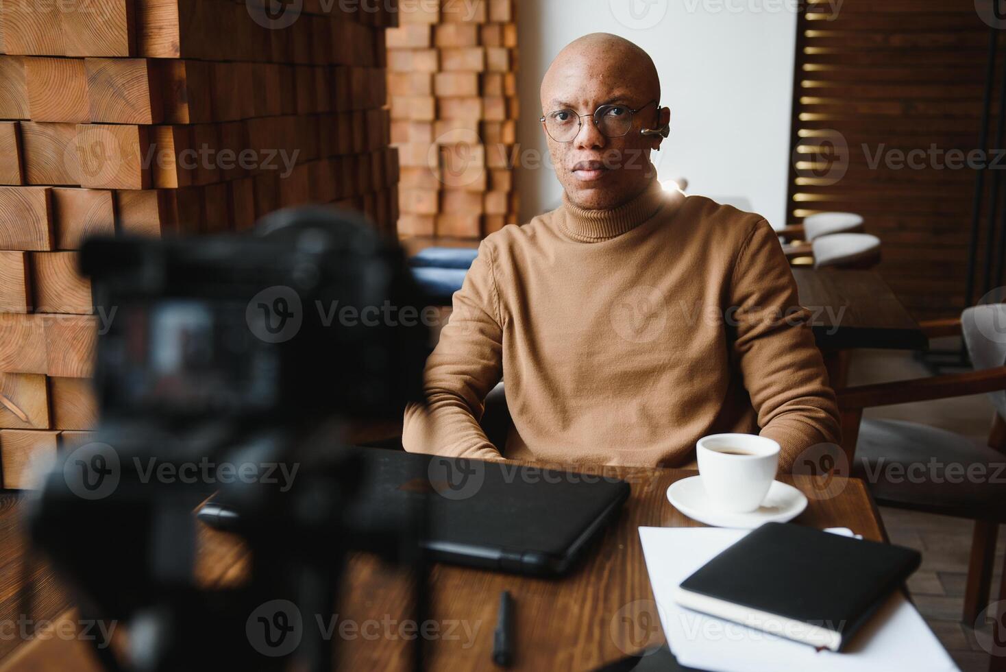 African-Ameican entrepreneur wearing shirt with rolled up sleeves looking through window with thoughtful and serious face expression, feeling nervous before meeting with business partners at cafe. photo