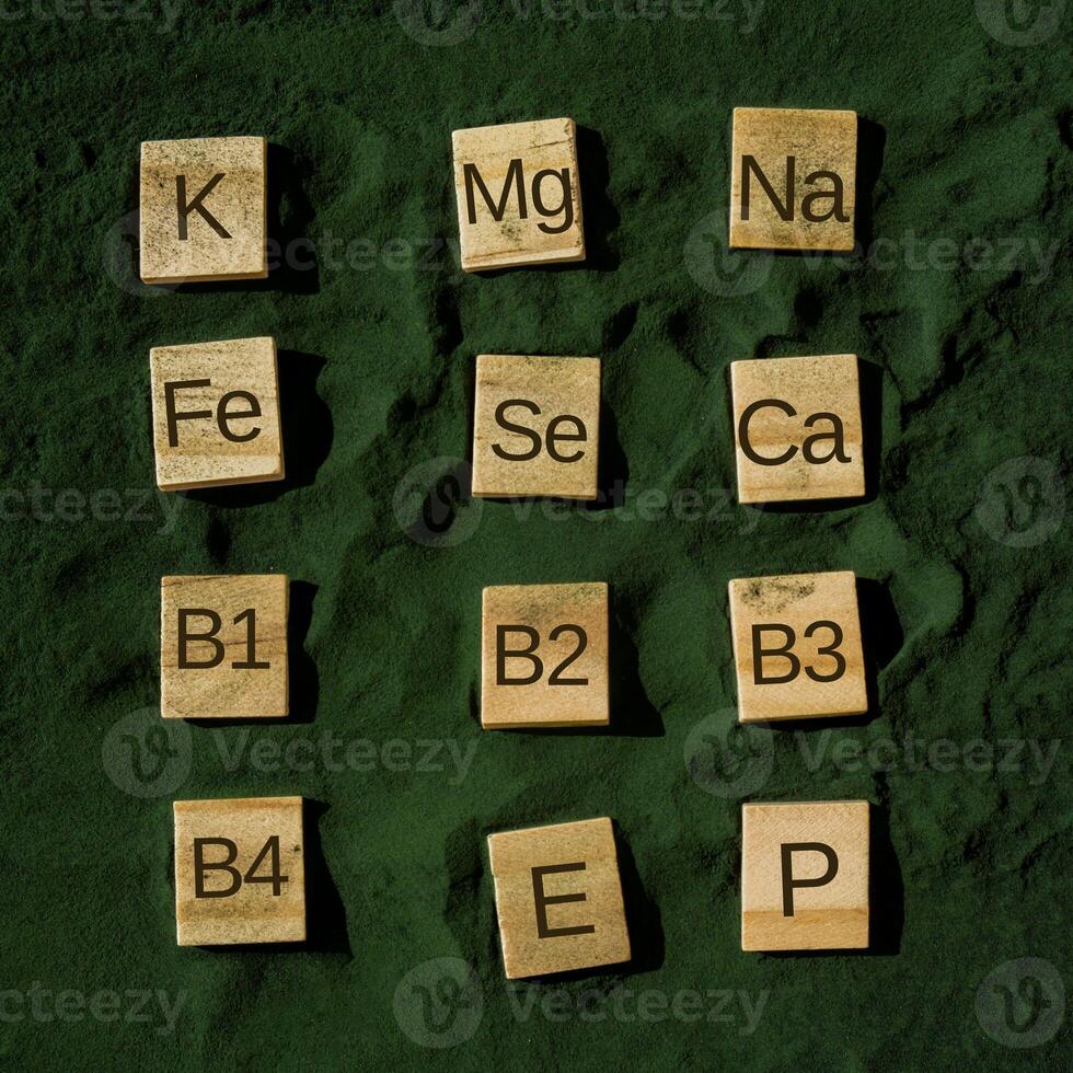 Wooden blocks with text of vitamins in spirulina chlorella algae superfood powder. Vitamin K Mg Na Fe Se Ca B1 B2 B3 B4 E P. Healthy benefits supplement and vegan antioxidant healthy eating concept photo