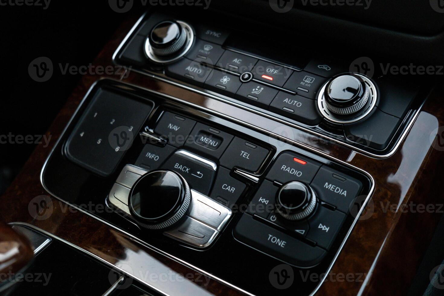 Interior of modern luxury car. Details of automatic transmission gear shift, multimedia control system, car control panel, Air Vent Red emergency button and dashboard inside. Prestige sport automobile. Selective focus photo