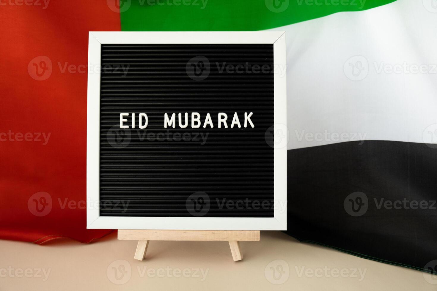 Message text EID MUBARAK - happy holidays waving UAE flag on background concept. Greeting card advertisement. Commemoration Day Muslim Ramadan Blessed holy month public holiday. Patriotism photo