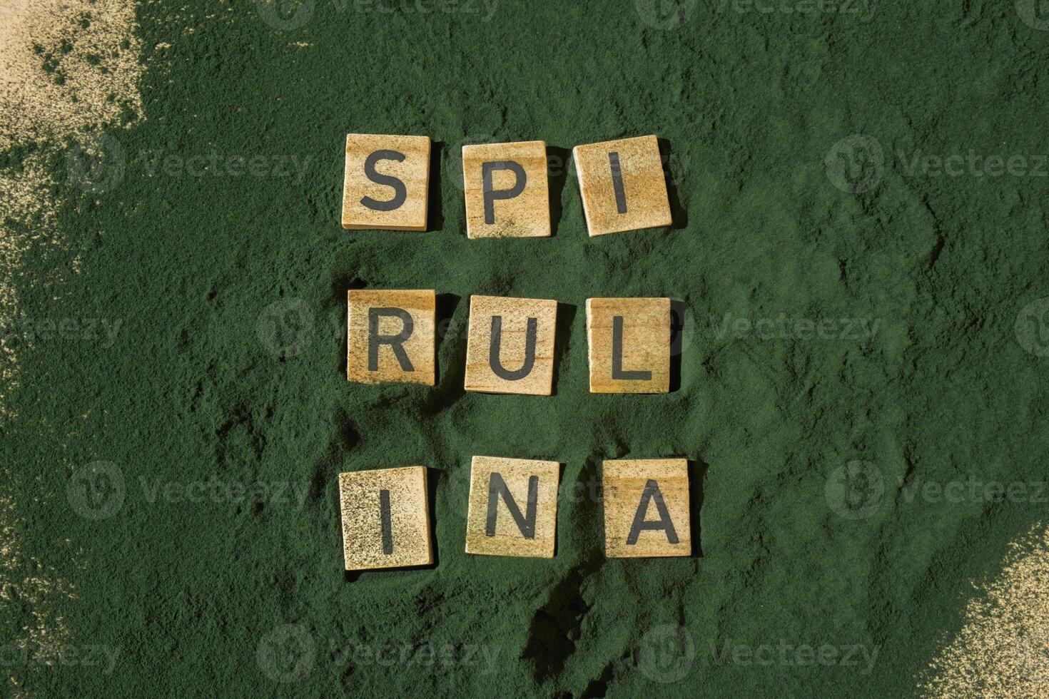 Wooden blocks with text SPIRULINA chlorella on background of algae superfood powder. Healthy benefits supplement and vegan antioxidant healthy eating concept photo