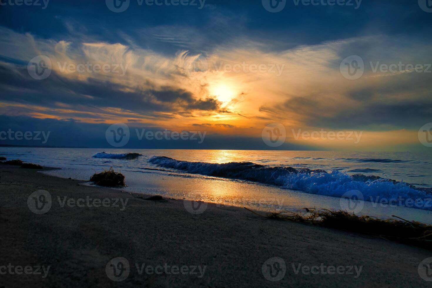 Sunset, illuminated sea. Sandy beach in the foreground. Light waves. Baltic Sea photo
