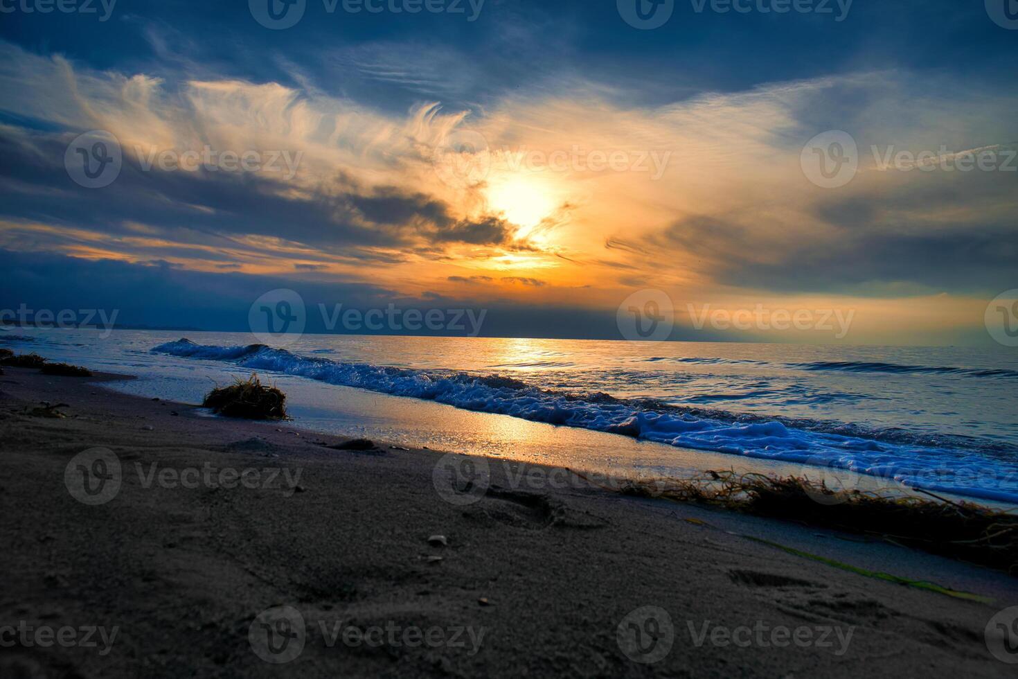 Sunset, illuminated sea. Sandy beach in the foreground. Light waves. Baltic Sea photo