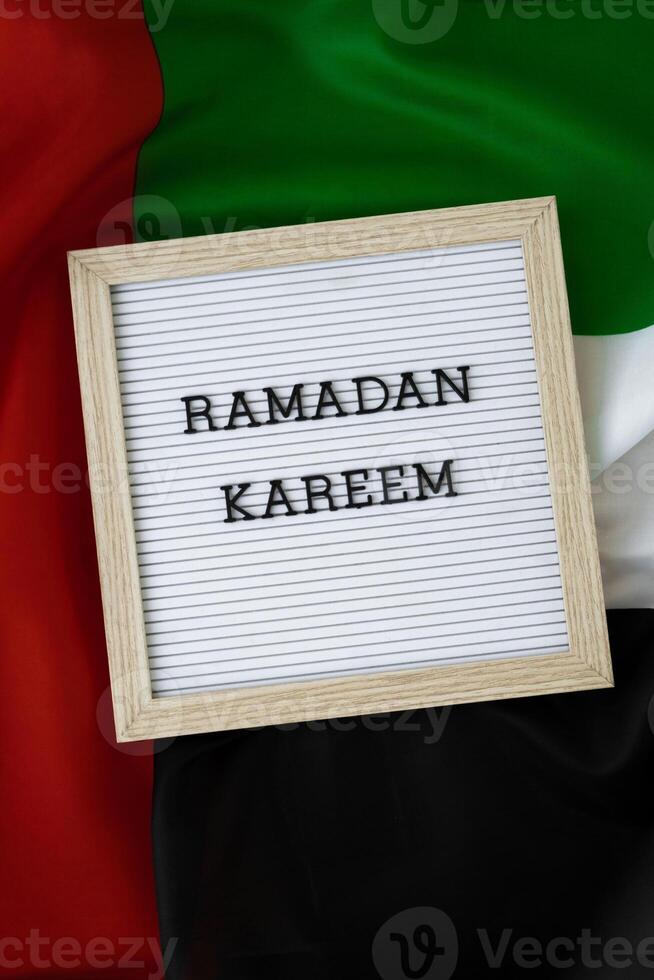 Congratulations with text RAMADAN KAREEM - happy holidays waving UAE flag on background concept. Greeting card advertisement. Commemoration Day Muslim Blessed holy month public holiday photo