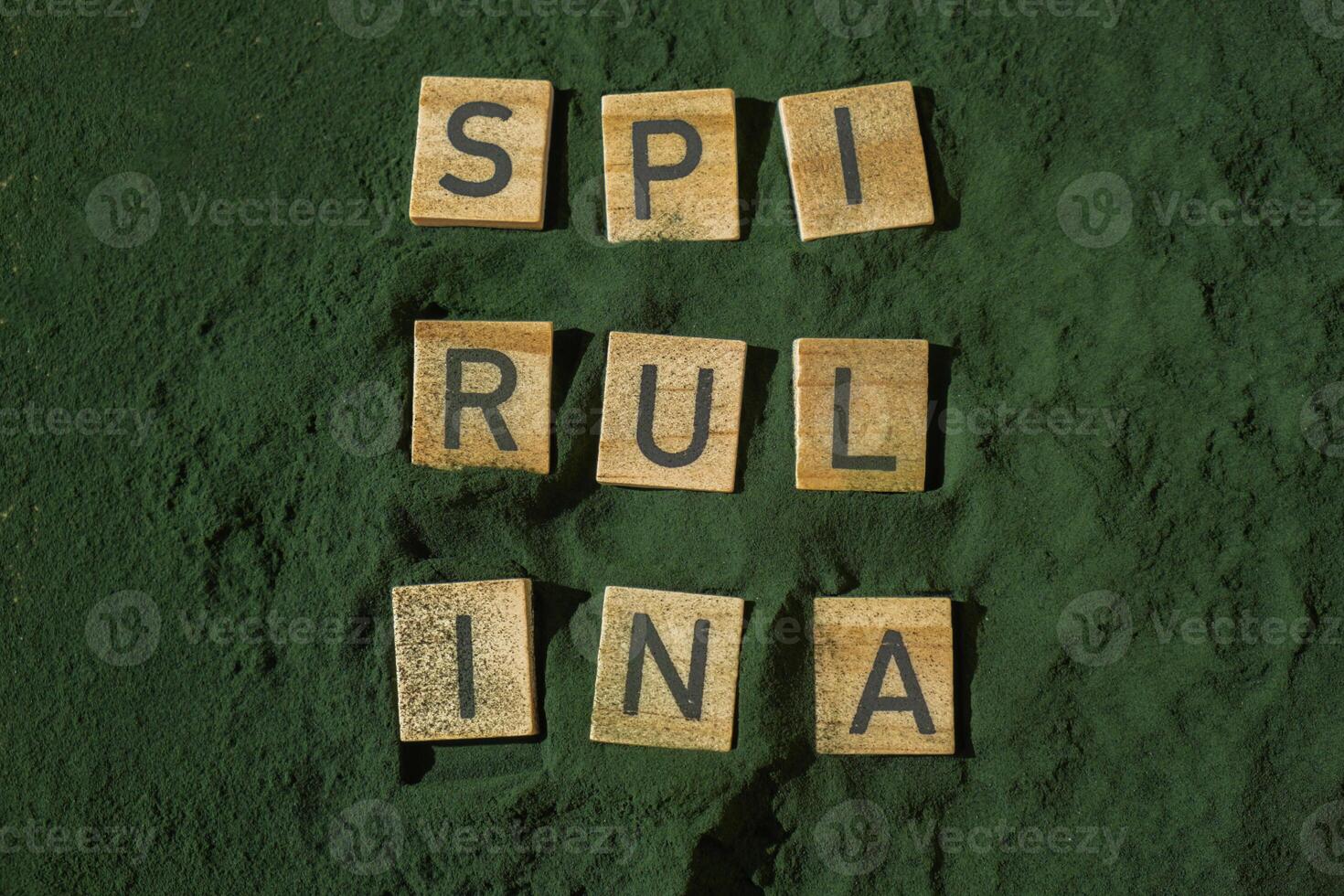 Wooden blocks with text SPIRULINA chlorella on background of algae superfood powder. Healthy benefits supplement and vegan antioxidant healthy eating concept photo