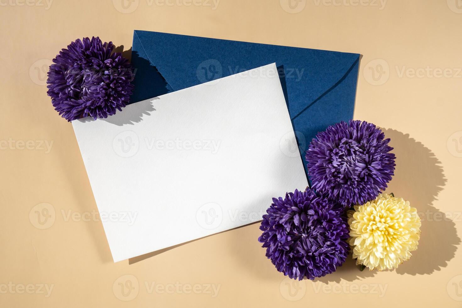 hermosa pequeño Violeta flores en postal azul sobre en beige fondo, vacío papel Nota Copiar espacio para texto, primavera tiempo, saludo tarjeta para día festivo. flor entrega concepto foto