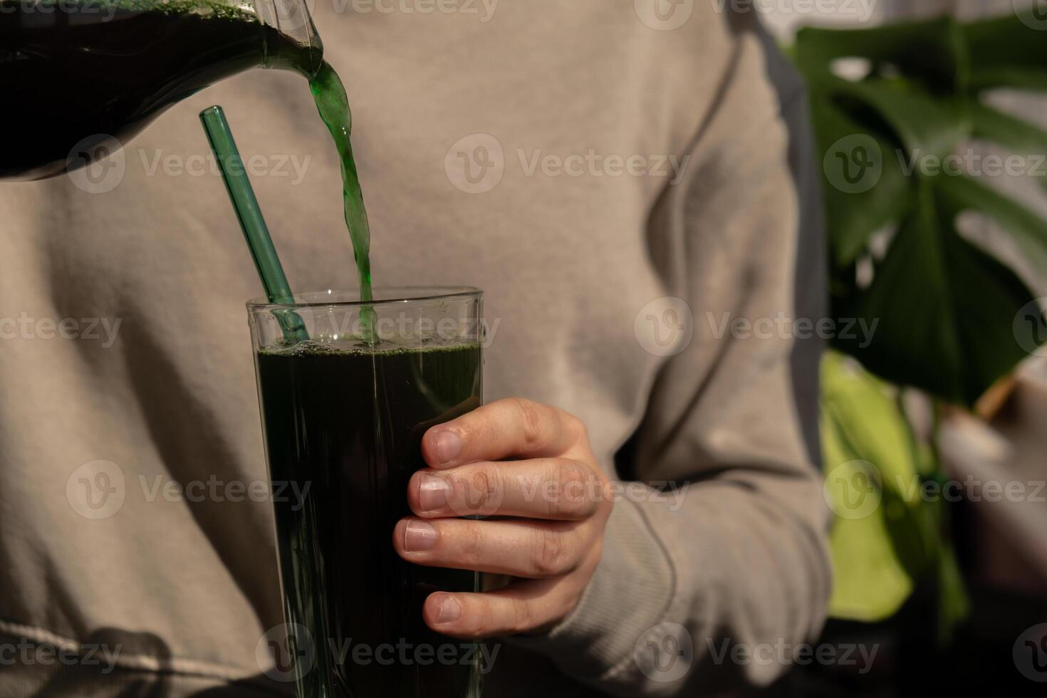 Female hands holding Organic blue-green algae spirulina detox drink in glass powder food. Health protein cocktail smoothie of chlorella. Vitamins and minerals to diet. Prebiotic and antioxidant rich Dietary supplement Seaweed superfood concept photo