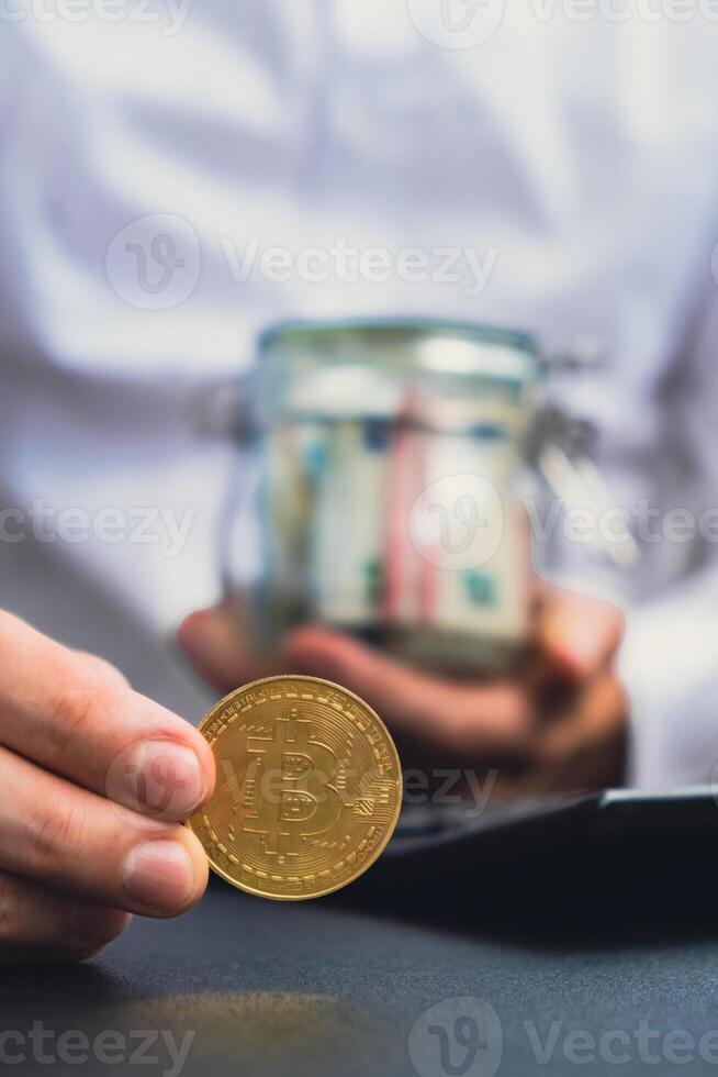 Bitcoin coin digital gold next to Expert trader hands counting income banknotes of euro cash from glass jar. Close up of hands unrecognizable Freelancer. Earned trading charts growth Cryptocurrency market investment concept. Euro fund savings footage photo