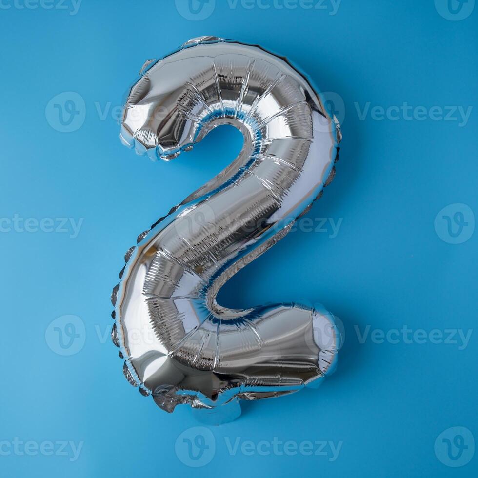 2 two metallic balloon isolated on blue background. Greeting card silver foil balloon number Happy birthday holiday concept. Copy space for text. Celebration party congratulation decoration photo