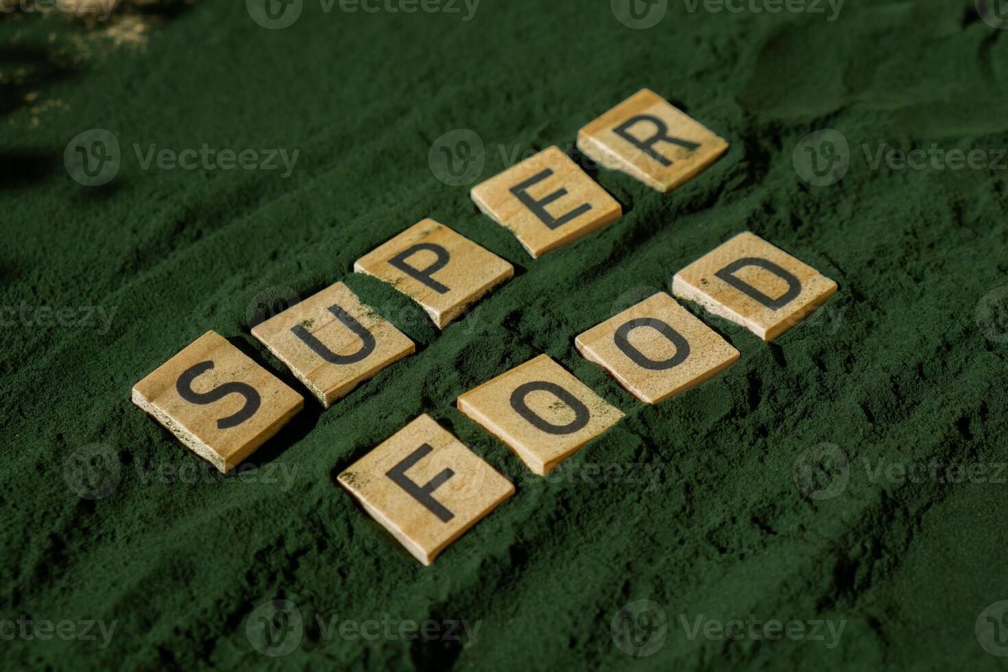 SUPERFOOD letter chlorella on green background of algae superfood. Organic blue-green algae spirulina powder food. Healthy benefits of natural supplement. Alternative medicine mineral food antioxidant healthy eating concept photo