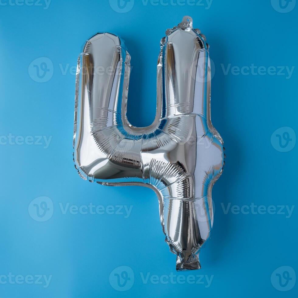 4 four metallic balloon isolated on blue background. Greeting card silver foil balloon number Happy birthday holiday concept. Copy space for text. Celebration party congratulation decoration photo