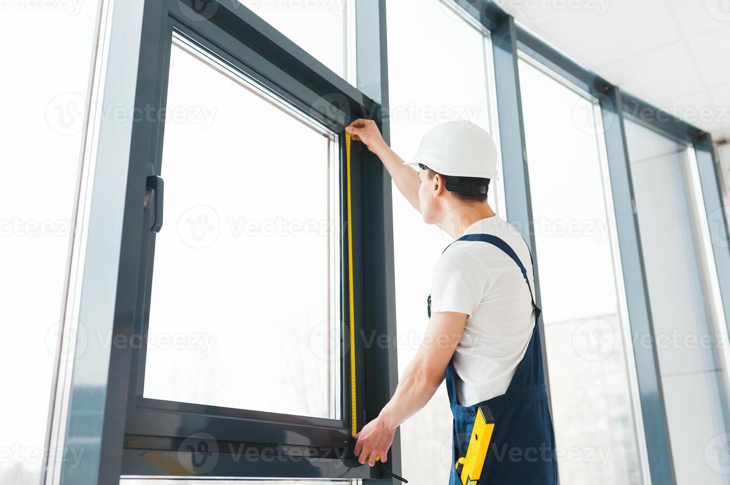 Construction worker installing window in house photo