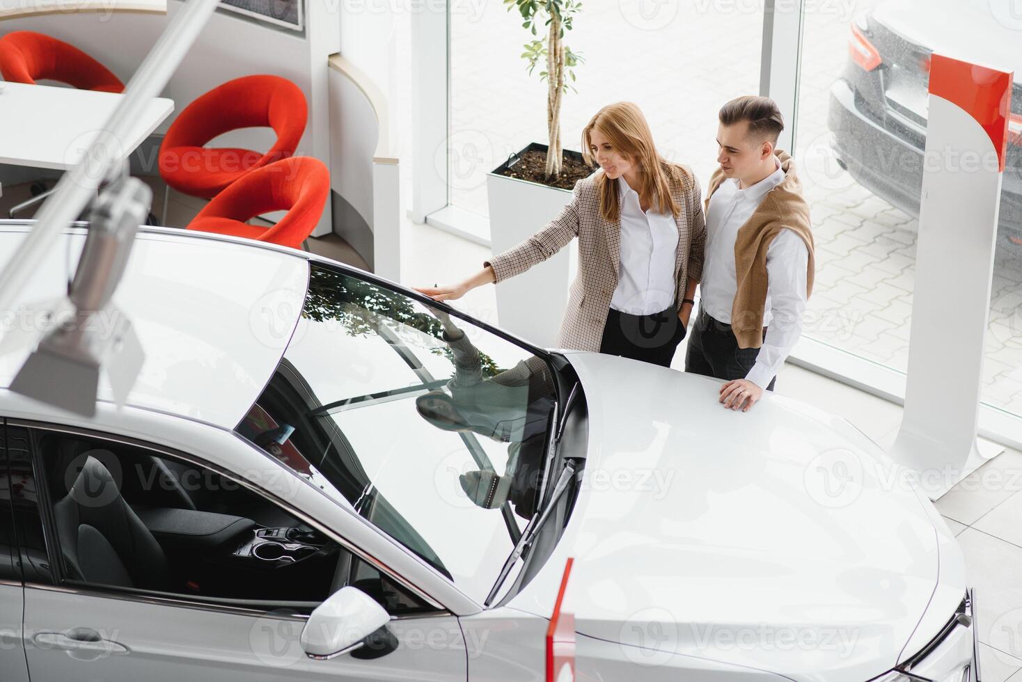 joven hermosa contento Pareja comprando un coche. marido comprando coche para su esposa en un salón. coche compras concepto foto