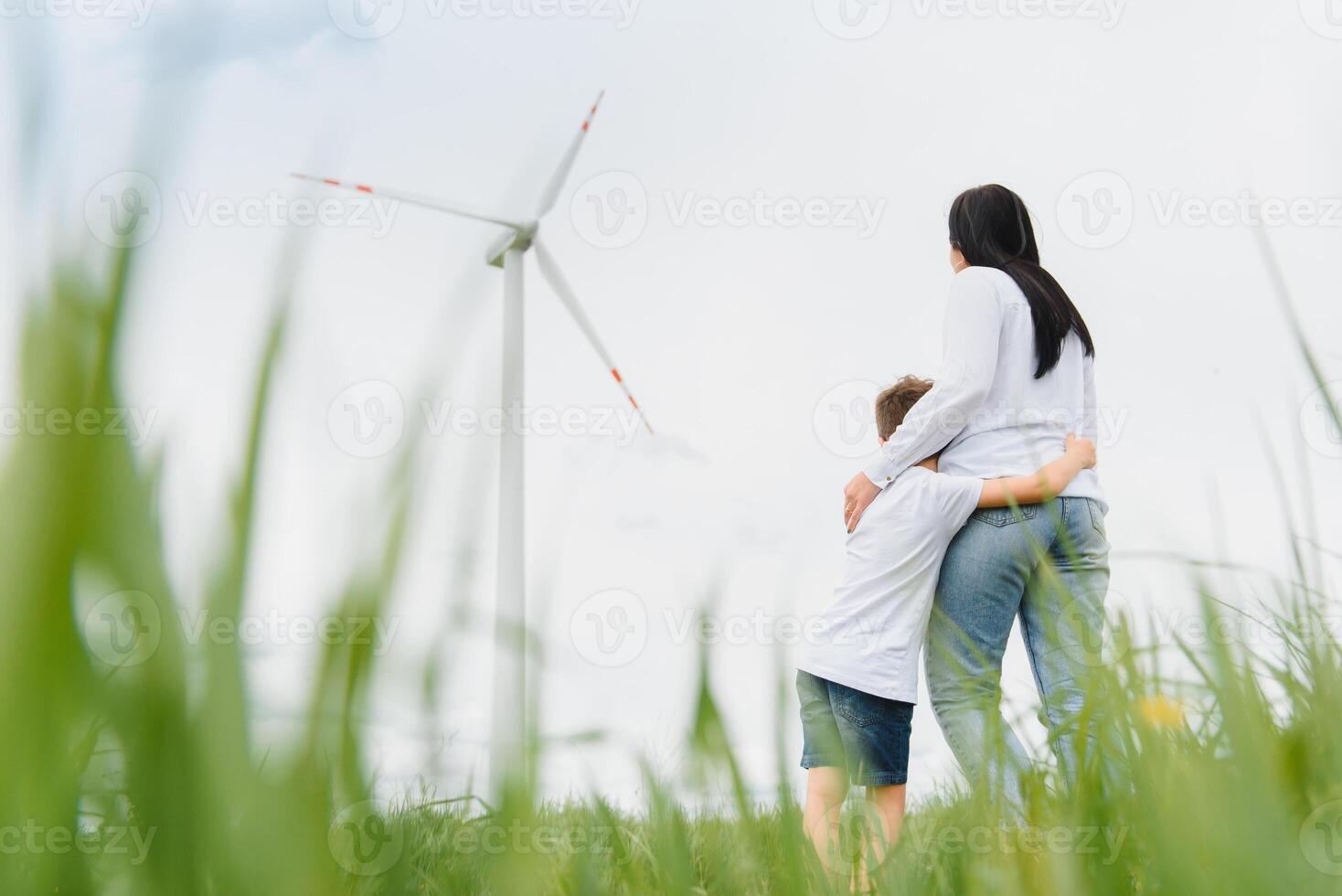 Alternative energy, wind farm and happy time with your family. Happy mother on the road with his son on vacation and escape to nature. photo