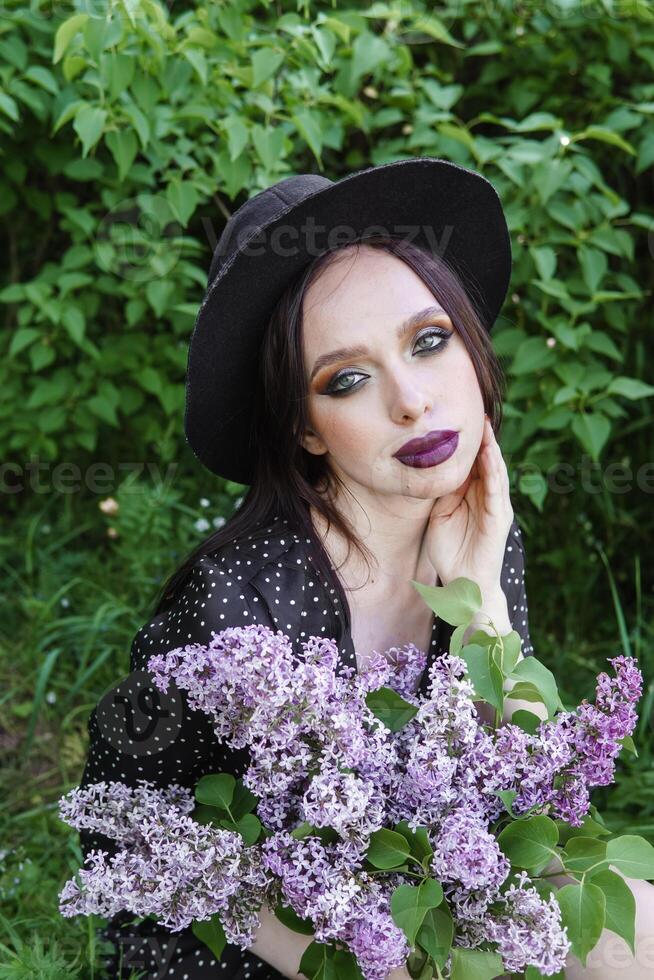 A fashionable girl with dark hair, a spring portrait in lilac tones in summer. Bright professional makeup. photo