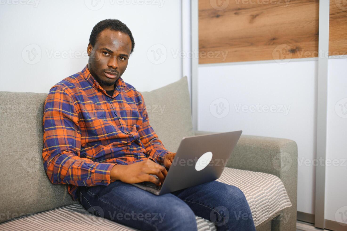 Connecting with an online world. Shot of a happy young man using a laptop while relaxing at home photo