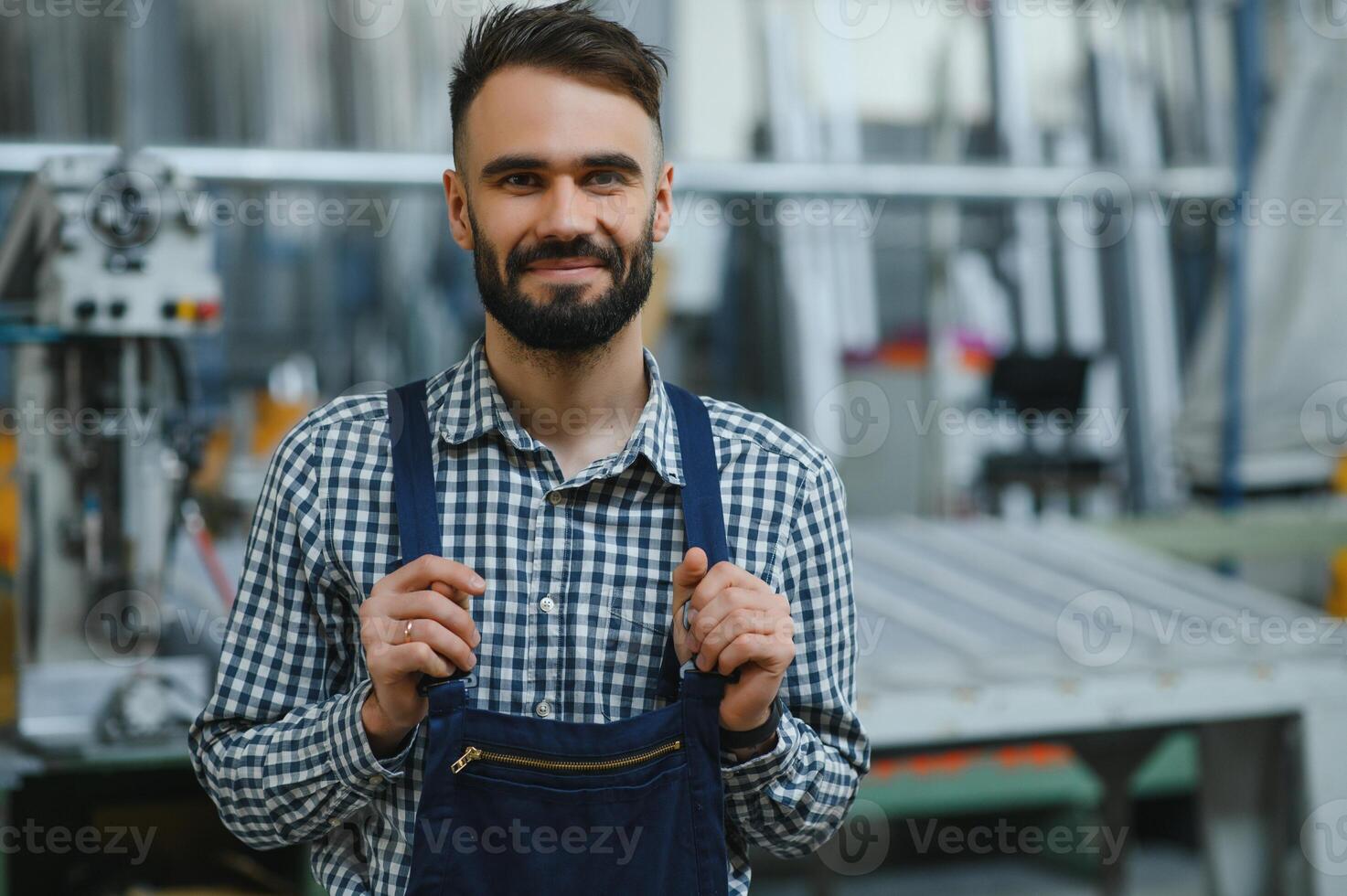 Happy Professional Heavy Industry Engineer Worker Wearing Uniform, and Hard Hat in a Steel Factory. Smiling Industrial Specialist Standing in a Metal Construction Manufacture photo