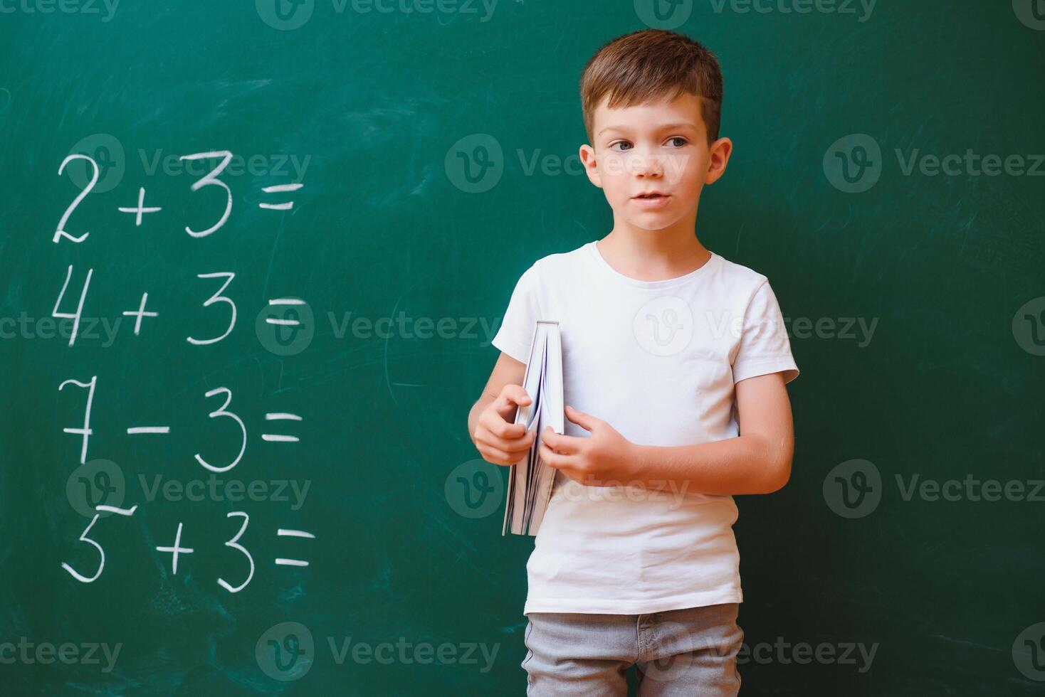 Back to school concept. School child in class. Happy kid against green blackboard. Smart child in classroom. Idea and education concept photo