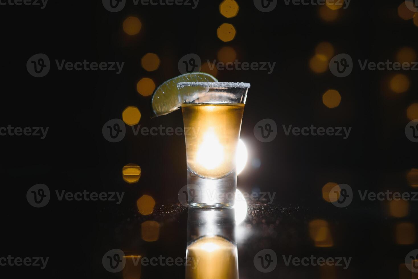 Tasty alcohol drink cocktail tequila with lime and salt on vibrant dark background. Closeup. photo