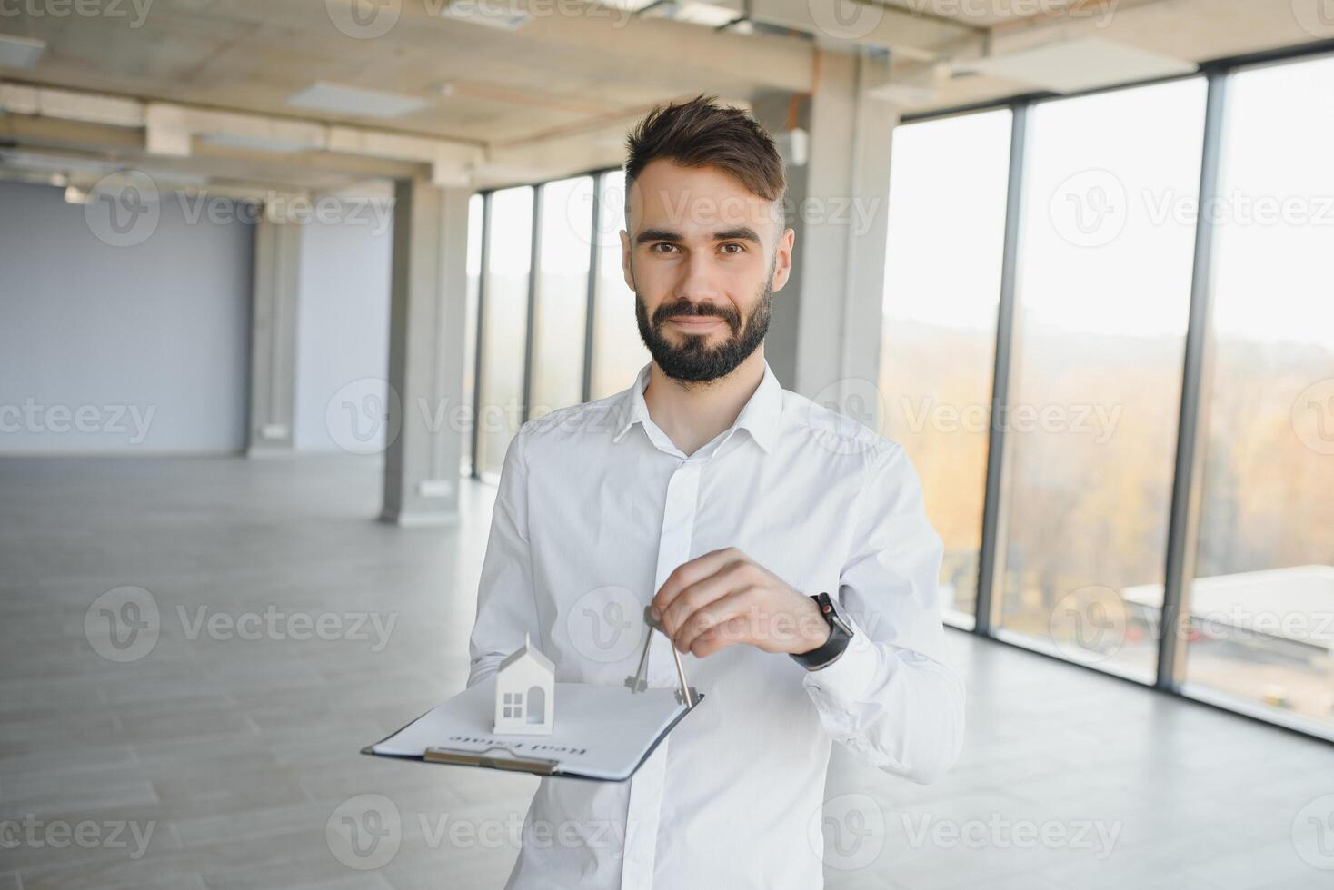 Male real estate agent with key in room. Banner for design photo