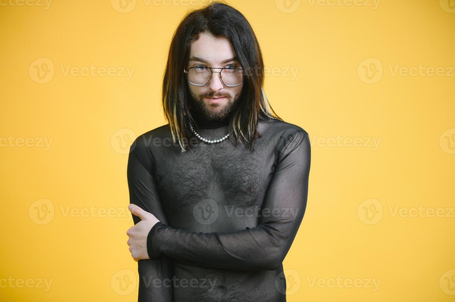 Young gay man is standing in the studio and posing for a camera. photo