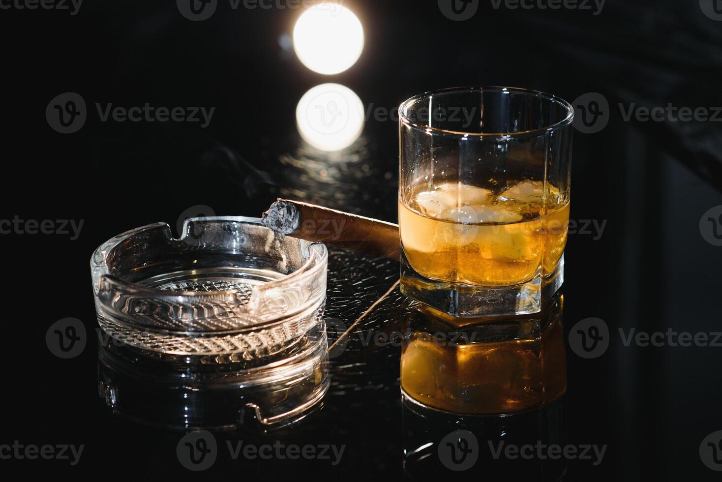 Whiskey drink with smoking cigar photo