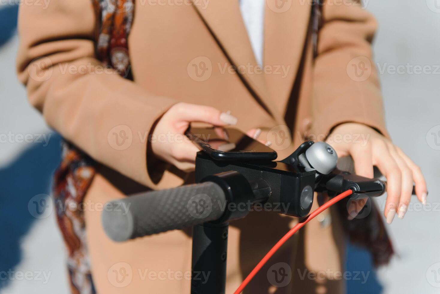 a young woman unlocks an e-scooter with her mobile phone photo