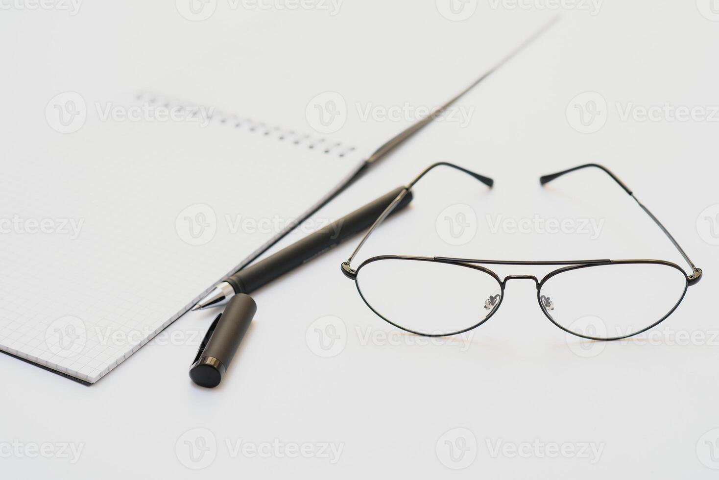 opened notebook with pen and glasses isolated photo