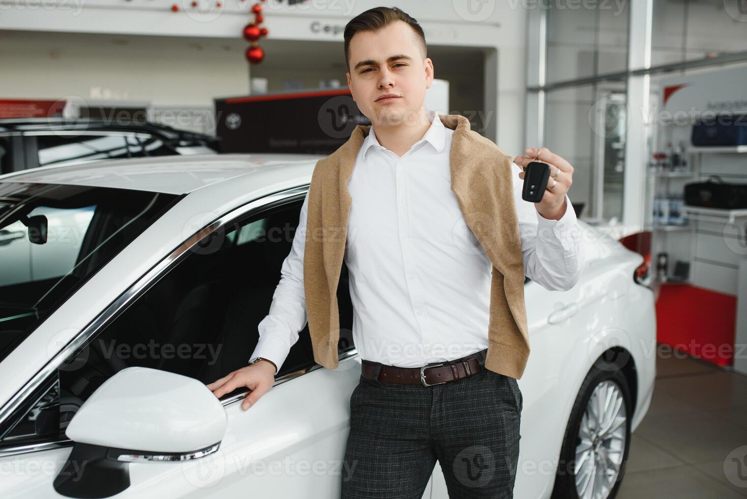Young man with the keys at the car. photo