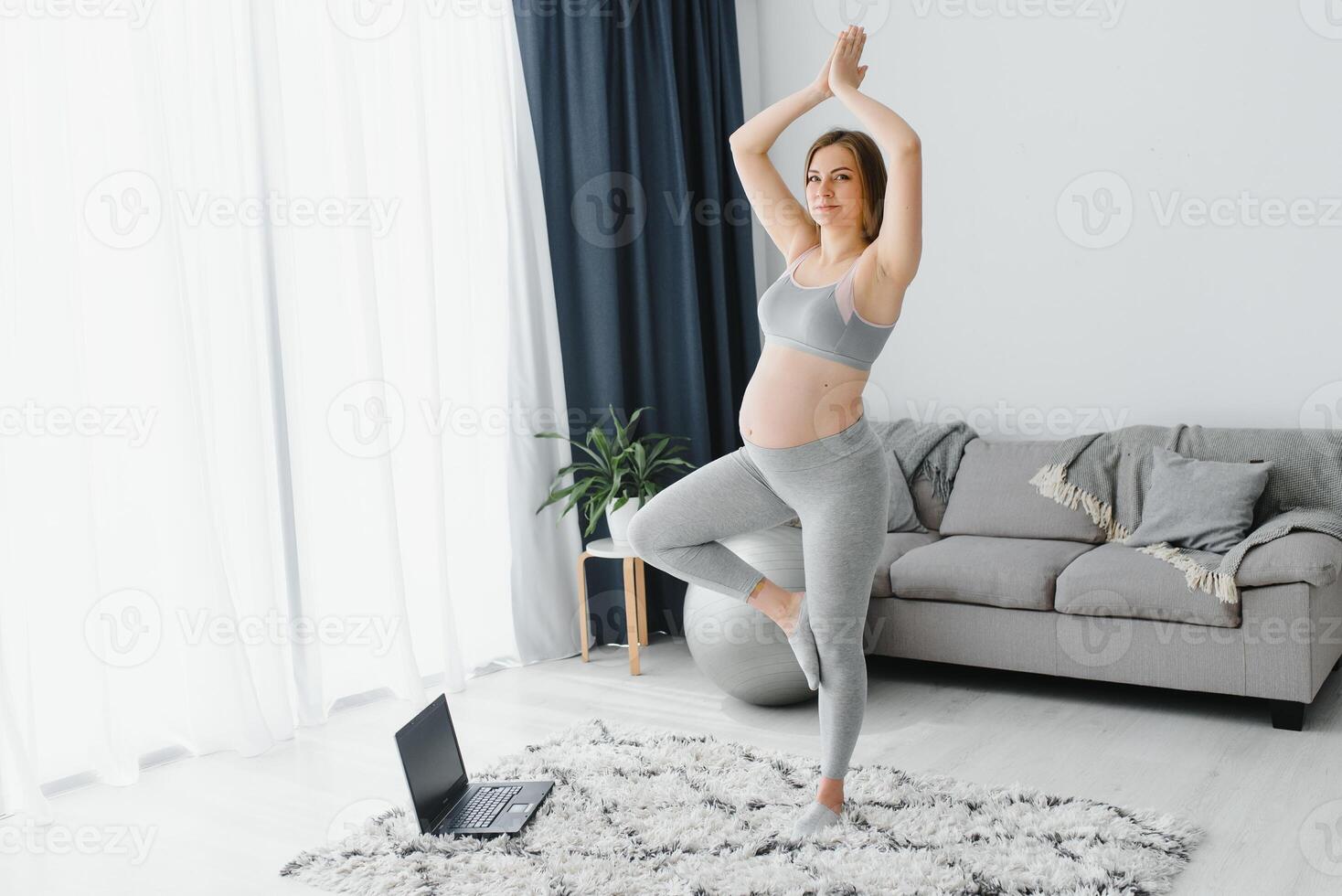 joven embarazada mujer hacer yoga adentro foto