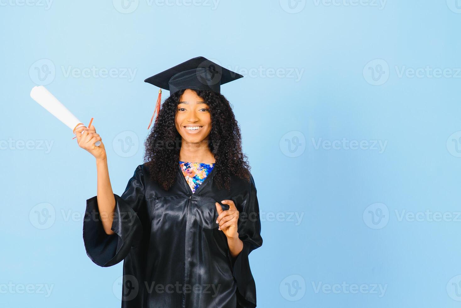 afroamericano hermosa mujer en un negro túnica y sombrero, en un azul aislado antecedentes sonrisas foto
