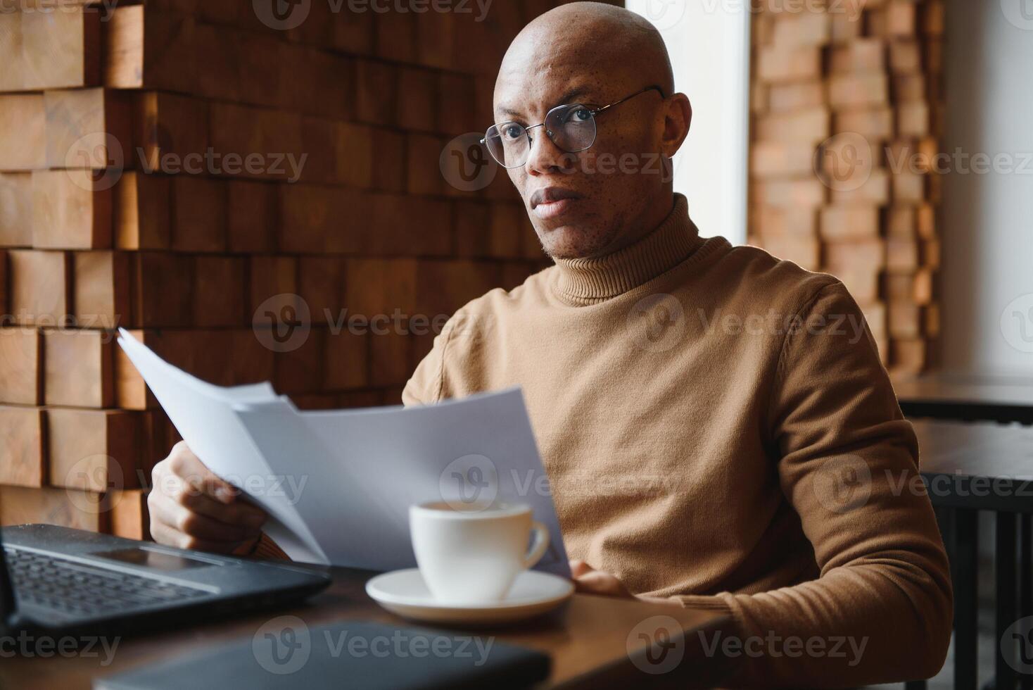 Close up portrait of young man sitting in cafe working on laptop computer. photo