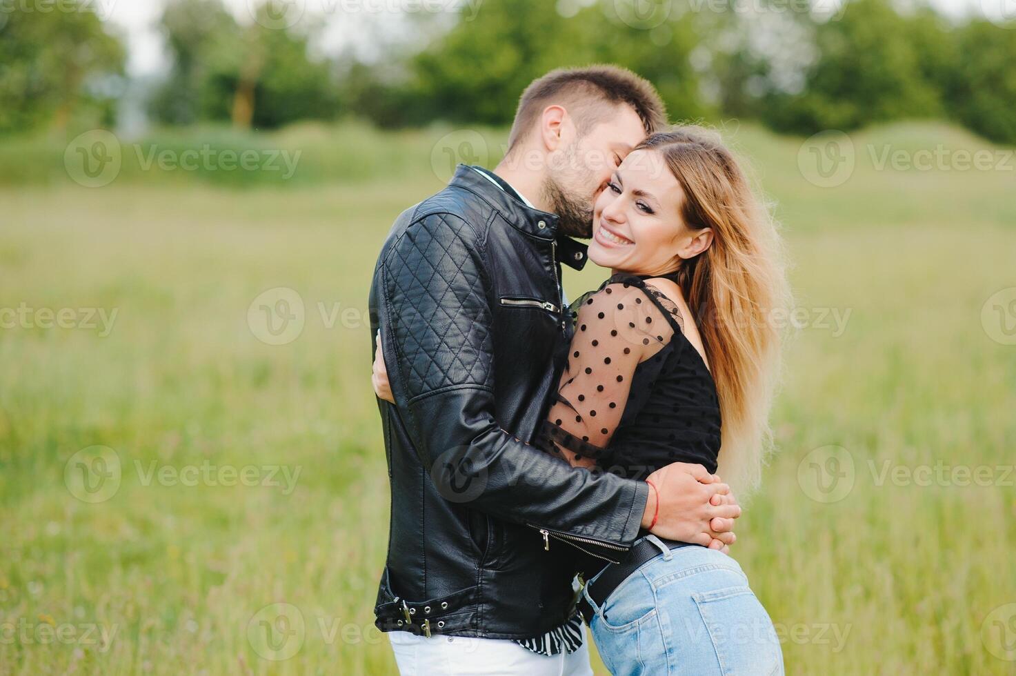 joven Pareja camina en el parque durante el primavera y abrazos. disfrutando hora juntos. el concepto de juventud, amor y estilo de vida foto