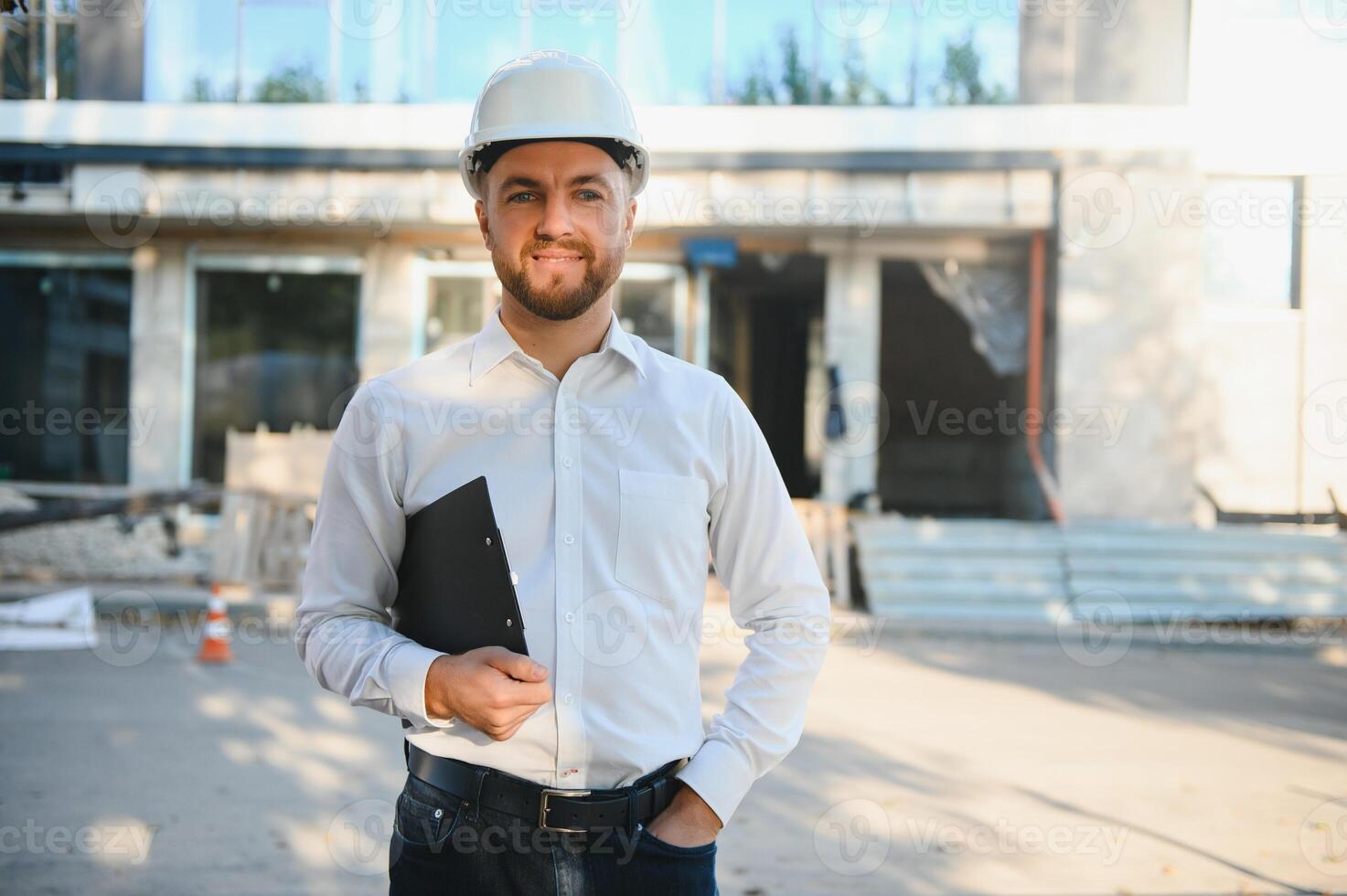 Engineer next to building cranes. Concept - large construction project. Architect directs the construction process. Drawings and tablet in the hands. photo