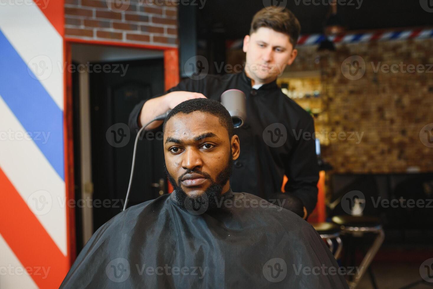 joven afroamericano hombre visitando barbería foto