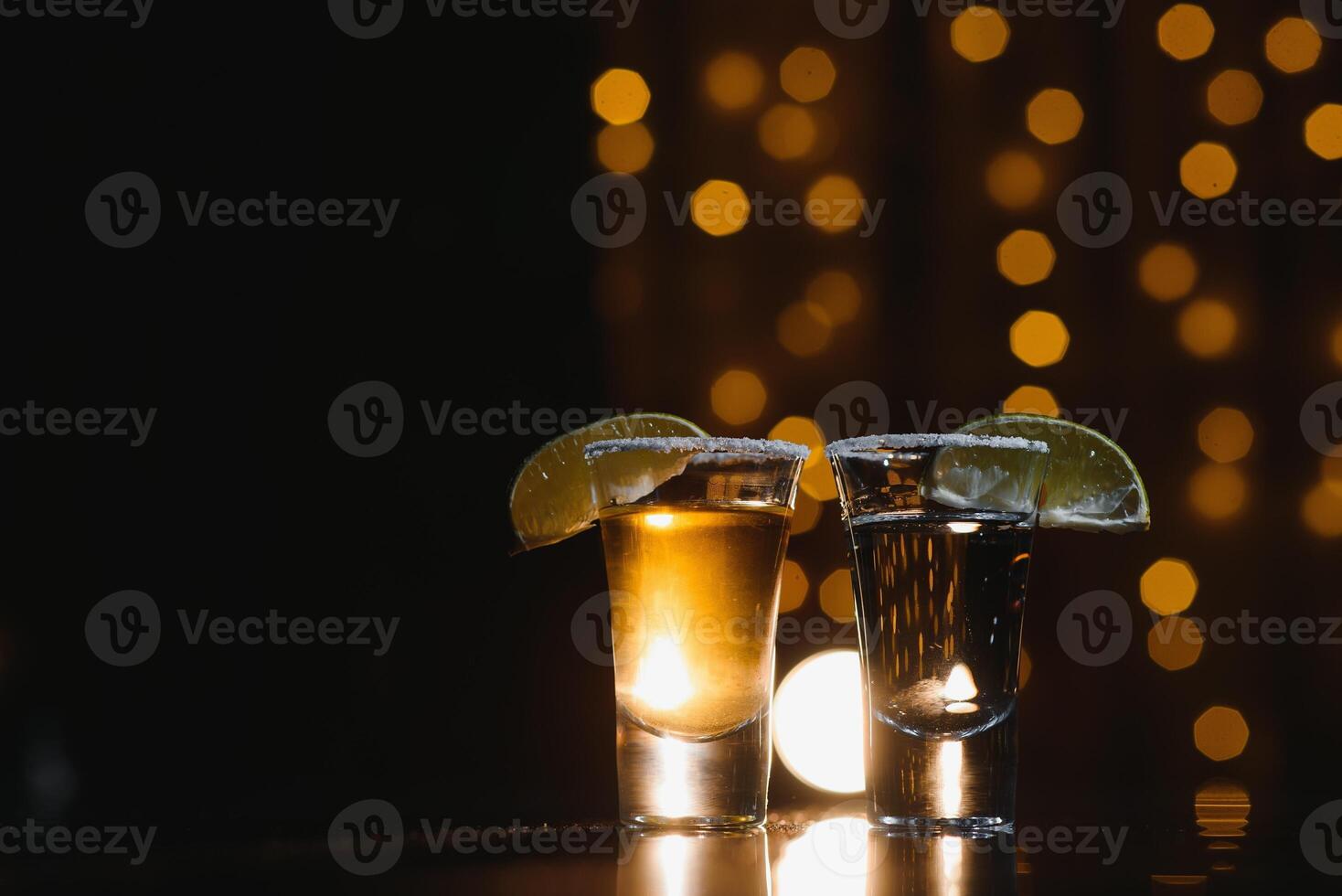 Tasty alcohol drink cocktail tequila with lime and salt on vibrant dark background. Closeup. photo