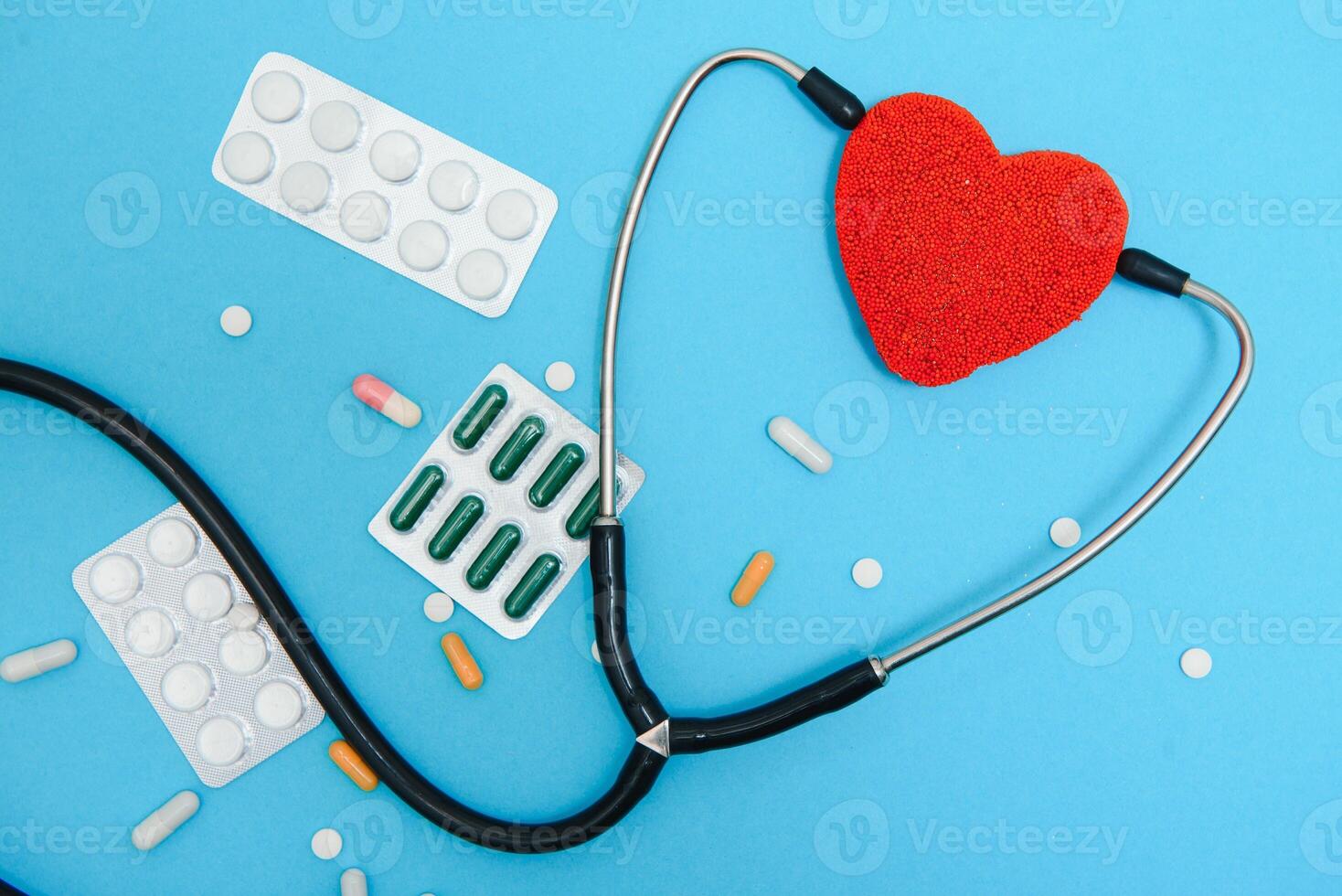 Global healthcare concept.Stylish doctor with heart on blue background.Close-up of red heart and stethoscope on a blue background. Listen to the heart with statoscope photo