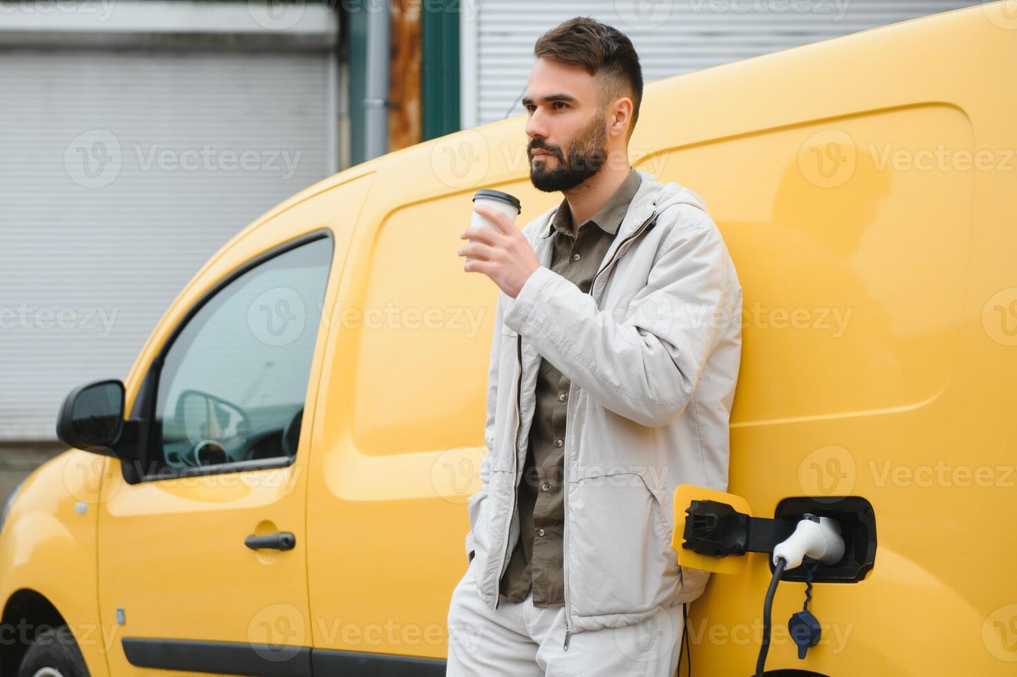 hombre cargando eléctrico coche por el trabajo foto