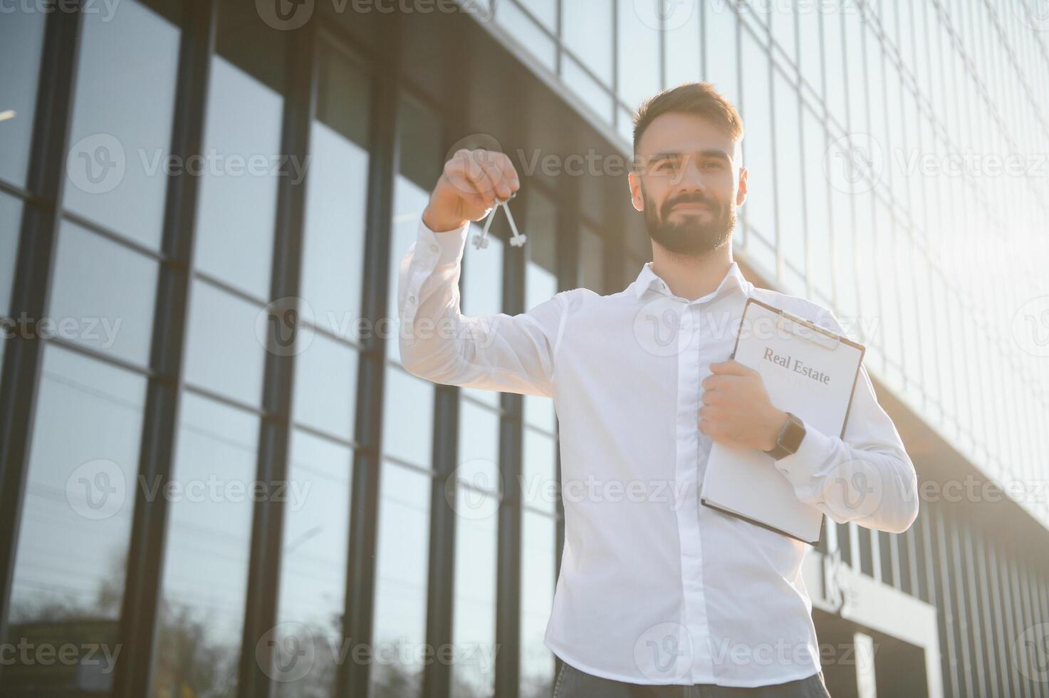 Businessman or real estate agent ready to discuss business and stands against new building photo