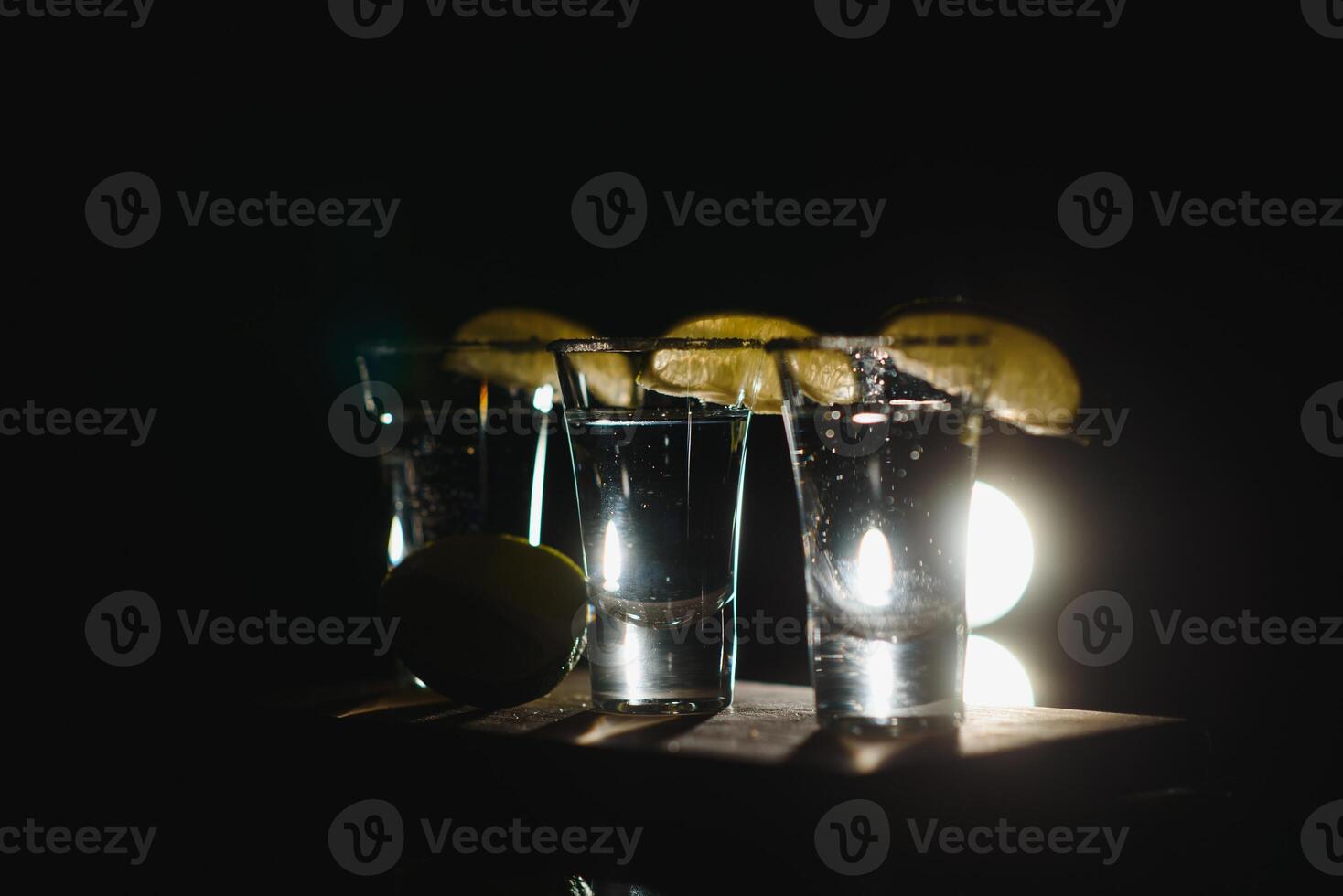 Tequila with lime and salt on black background photo