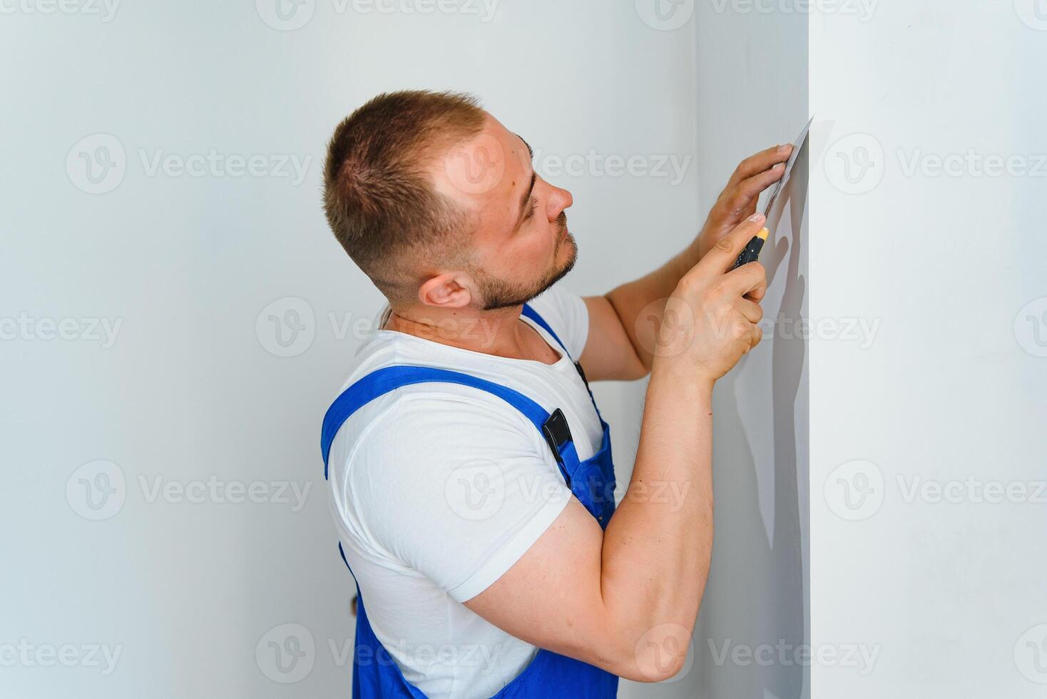 A man processes the wall with a spatula. Plasterer at work. photo