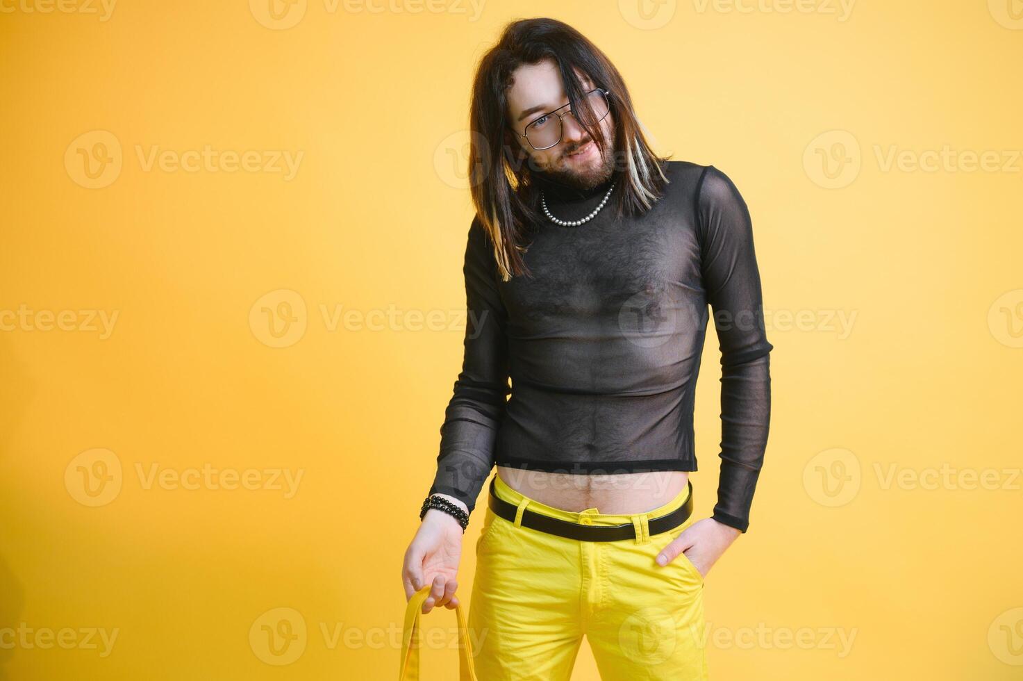 Young gay man is standing in the studio and posing for a camera. photo