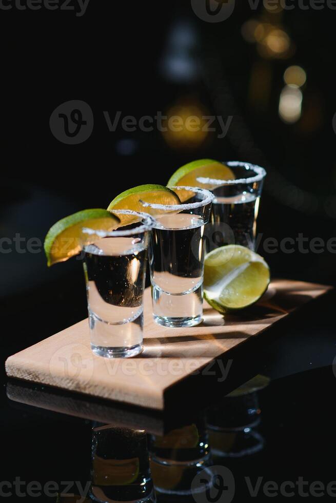 Tequila with lime and salt on black background photo