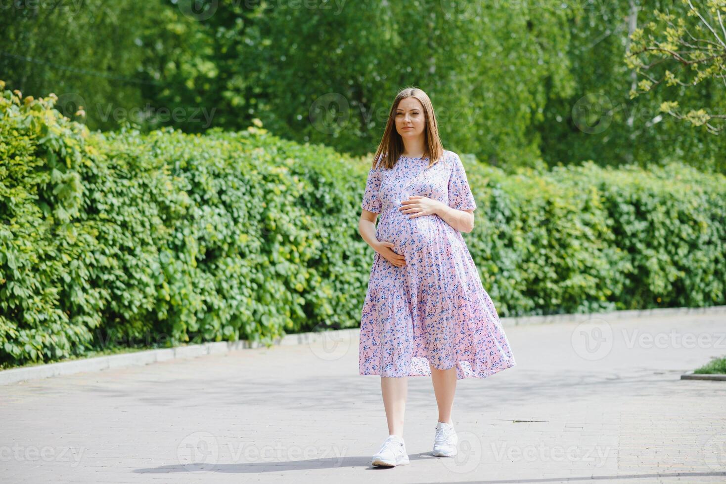 The pregnant girl on walk in city park photo