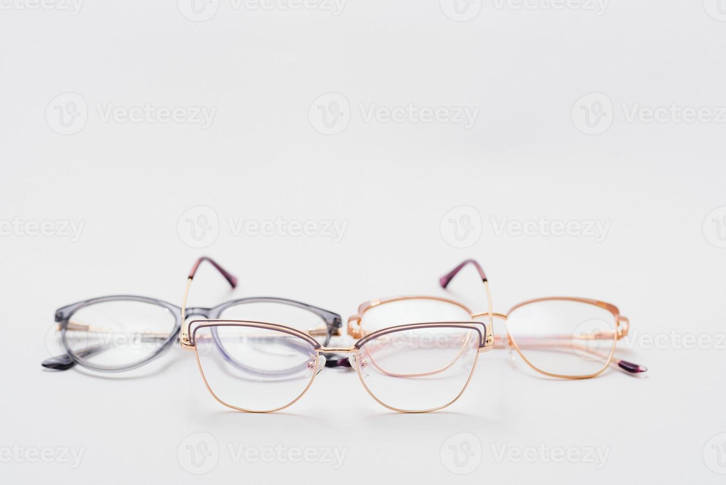 Stylish eyeglasses over background. Optical store, glasses selection, eye test, vision examination at optician, fashion accessories concept. Top view, flat lay photo