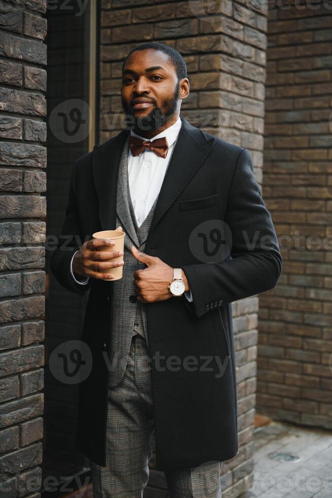 Young african american businessman drinking take away coffee at the city. photo