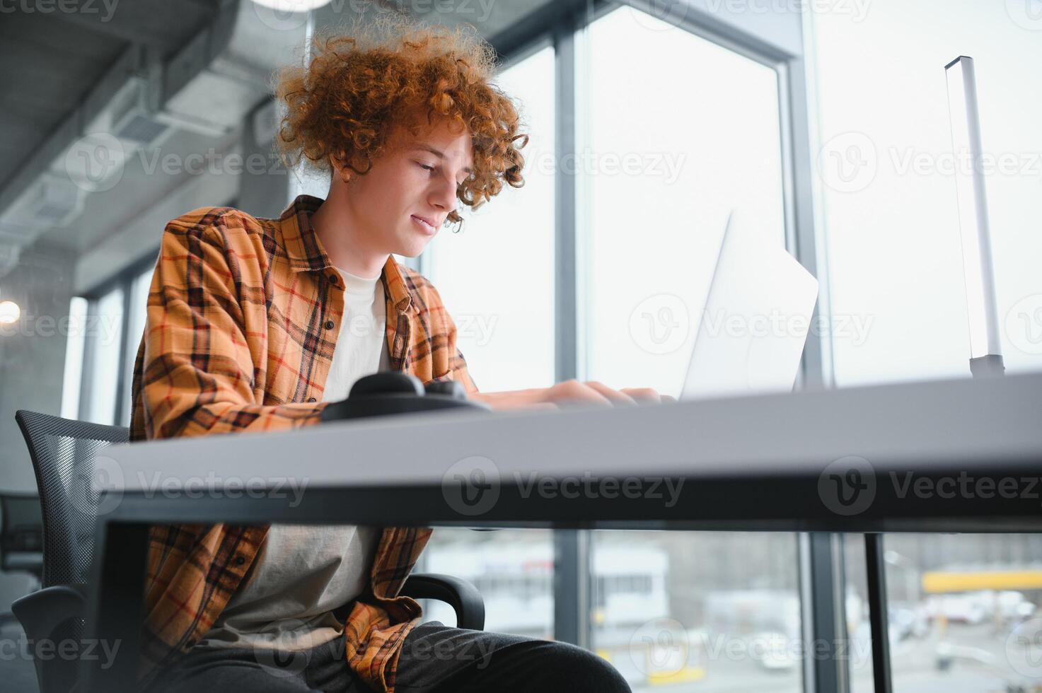 Cheerful male freelancer browsing funny video content while networking in social media using netbook technology in street cafe, happy hipster guy enjoying free time for online blogging via laptop photo