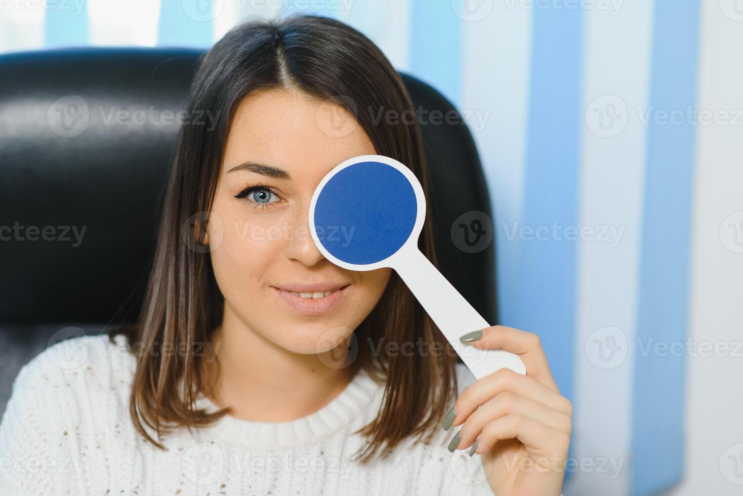 Young beautiful woman at the ophthalmologist's appointment checks her eyesight. Doctor ophthalmologist examines the patient. photo