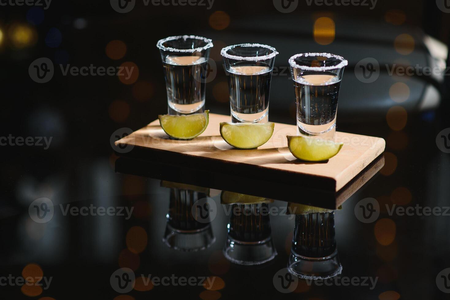 Tequila with lime and salt on black background photo